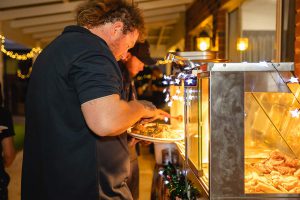 Image of team members filling plates at the buffet at the Topdrill Christmas party