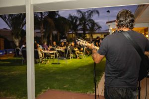Photo from behind the musician looking out towards the guests at the Topdrill Christmas party