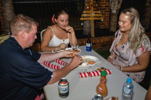 3 Topdrill team members sitting at a table celebrating at the Christmas party event